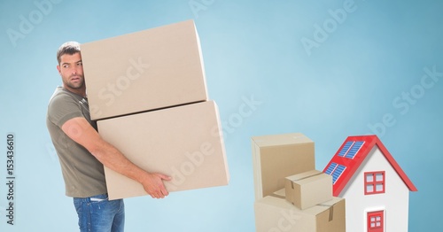 Delivery man carrying heavy parcels by house