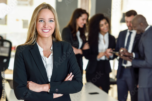 Businesswoman leader in modern office with businesspeople working at background