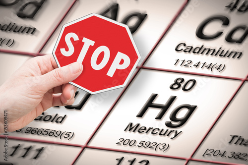 Stop heavy metals - Concept image with hand holding a stop sign against a mercury chemical element with the Mendeleev periodic table on background