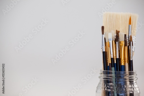 Varieties of paint brushes in glass jar