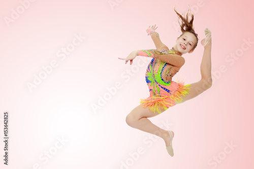 Girl gymnast performs a jump.