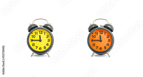 Closeup yellow alarm clock and orange alarm clock for decorate show a quarter to eleven o'clock or 11:45 a.m. isolated on white background