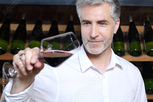 Winiarnia, mężczyzna degustuje czerwone wino