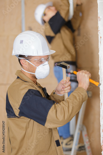 Workman using hammer and chisel