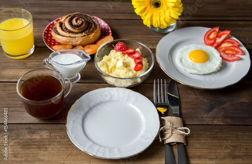 Breakfast table served with corn porridge, fried egg and juice