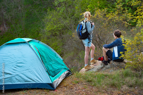 Attractive young couple camping trip in forest. Travel, tourism, hike and people concept.