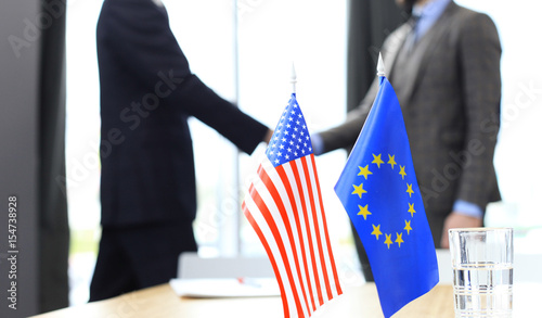 European Union and American leaders shaking hands on a deal agreement.