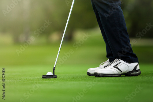 Golfer preparing for a putt on the green.