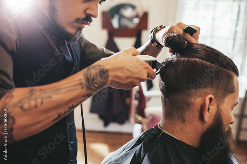 Man getting trendy haircut in barber shop