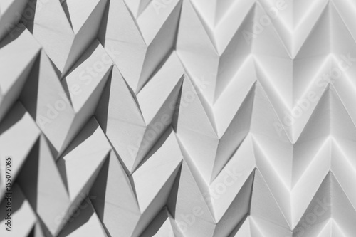 Closeup abstract white folded origami geometrical jigsaw paper pattern background