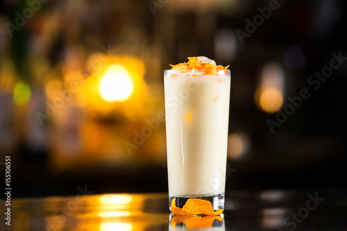 Closeup glass of pina colada cocktail at bright bar counter background.