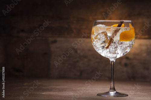 Gin and tonic cocktail on a wooden table with background