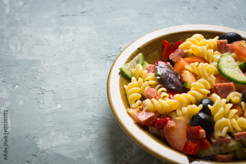 Fresh homemade pasta salad with tomatoes, olive and pepper. Shallow depth of field.