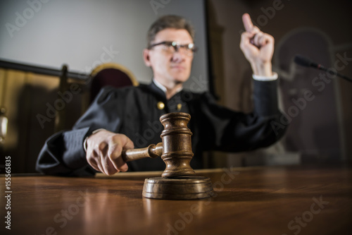 a judge with a hammer in his hand in the court room