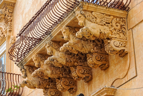 Wrought-iron balcony of the baroque Villadorata Palace in Via Nicolaci supported by five carved winged horses - Noto, Sicily, Italy