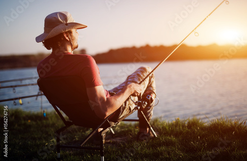 Men fishing in sunset and relaxing while enjoying hobby