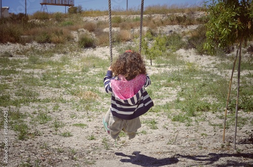 niña en columpio del árbol