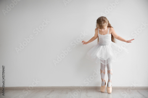Beautiful little ballerina in light dance studio