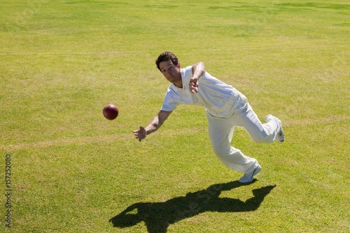 Full length of player catching ball on field