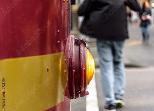 A close view of the front light of a Melbourne, Australia, city circle tourist tram with pedestrians in the background.