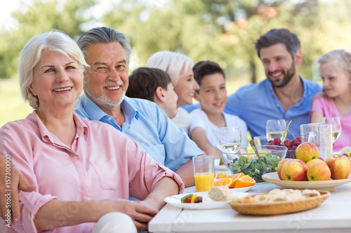 Extended family eating outdoors 