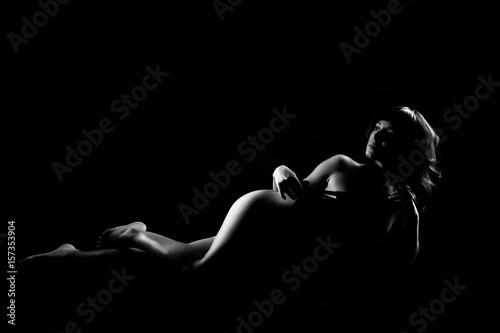Naked woman sexy silhouette, sensual nude female body on a dark background. Black and White