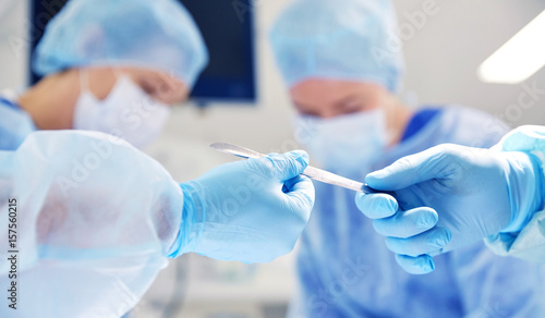 close up of hands with scalpel at operation