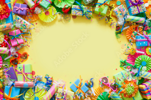 Gifts, garland, festive decor and confetti. Yellow background.