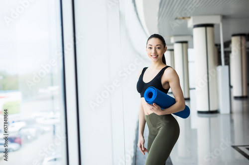 Woman practicing yoga at the gym with a blue mat