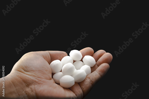 Moth balls on the male hand