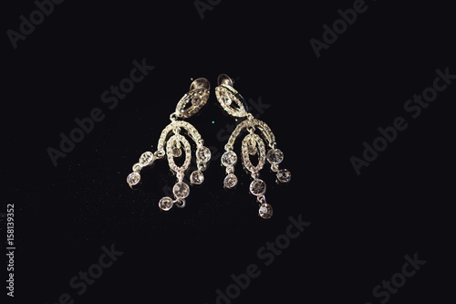Crystal earrings lie on black velvet