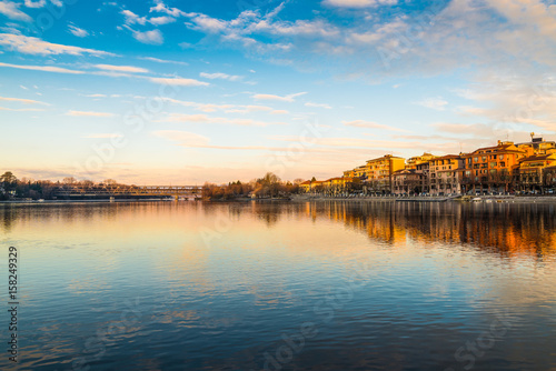 Sesto Calende, lake Maggiore, Ticino river, Italy. Beautiful sunrise on the promenade of Sesto Calende along the Ticino River at the exit from Lake Maggiore. It 'visible the iron bridge 