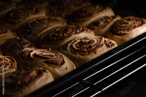 Cinnamon rolls during baking, high contrast, close up.