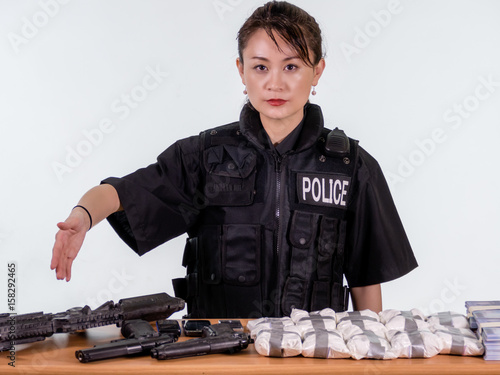 Female Asian police officer showing seized goods