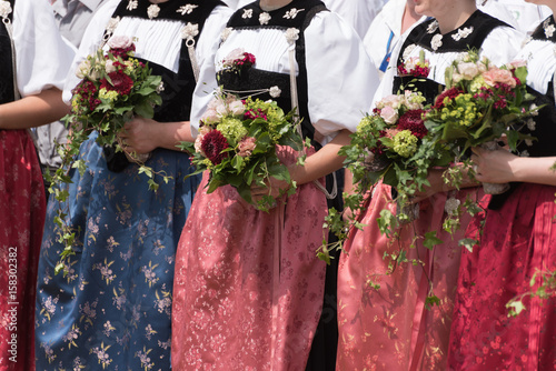 drei Frauen in schweizer Tracht mit Blumenstrauss