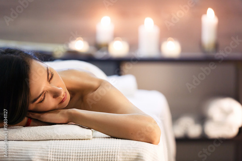 Beautiful girl in spa salon on candle background