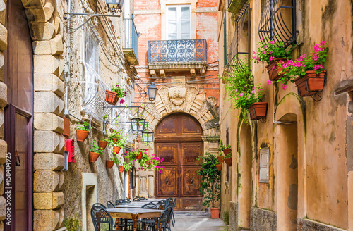 Cafe tables and chairs outside in old cozy street in the Positano town, Italy