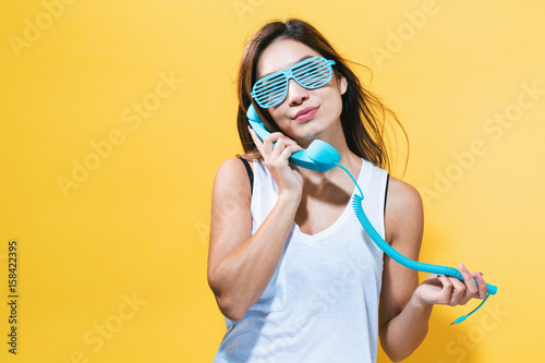 Young woman talking on old fashion phone