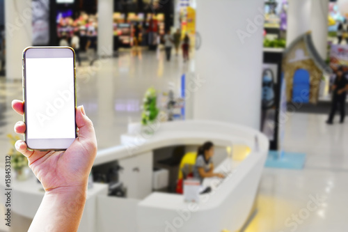 Hand holding smartphone for finding the information counter in the department store