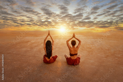 woman is practicing yoga on during sunset ,Woman Yoga - relax in nature,Young woman doing yoga in beach