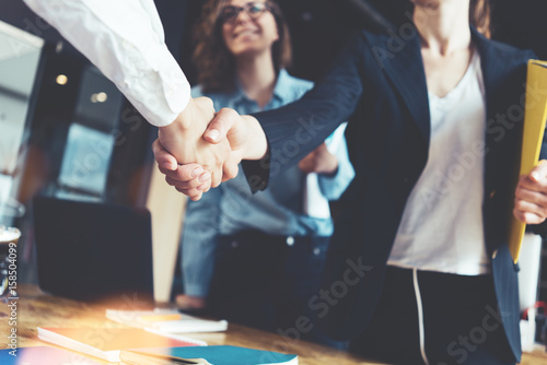 Young business people shaking hands in the office. Finishing successful meeting. Three persons