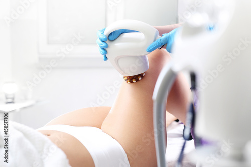Ujędrnienie skóry nóg. Kobieta w klinice medycyny estetycznej na zabiegu ujędrniającym i redukującym niedoskonałości sylwetki.
