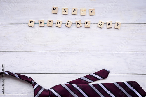 Happy Father's Day inscription with colorful red heart and hat on wooden background floor backround.