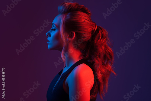 Fashion portrait of beautiful woman. Hairstyle. Blue and red light.