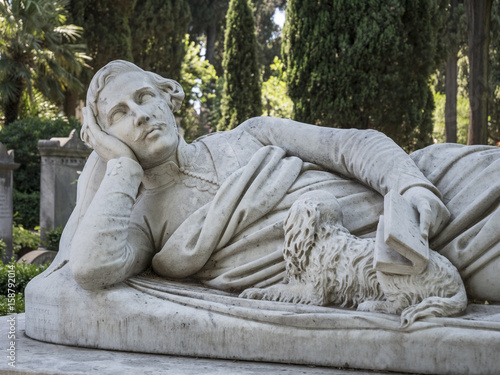 Sculpture of a lying man with a book in his hand and a dog. Protestant Cemetery in Rome