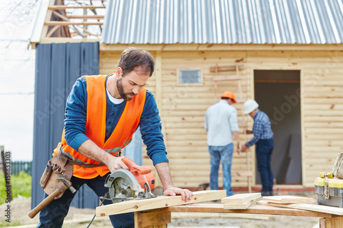 Handwerker mit Handkreissäge beim Hausbau