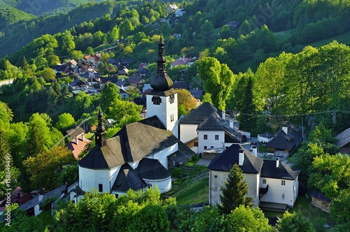 Spring in Slovakia. Old mining village. Historic church in Spania dolina. Springtime colored trees at sunset.