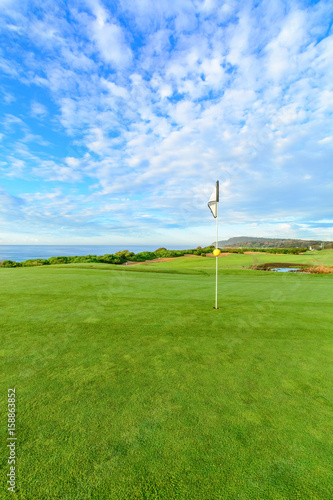 Golf pin on a beautiful seaside course with blue sky.