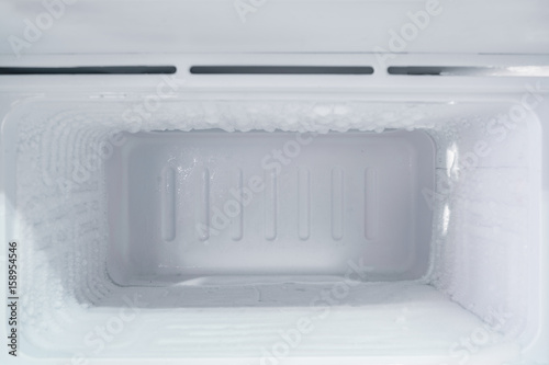 empty freezer of a refrigerator - Ice buildup on the inside of a freezer walls. 