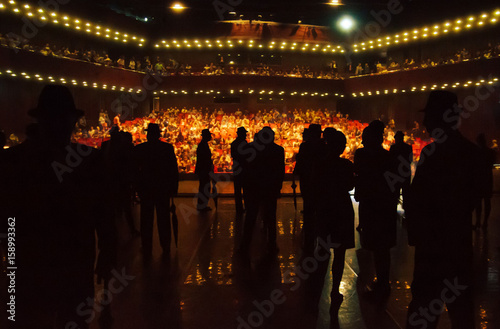 Actors performers on stage and audience waiting for show to start in theater